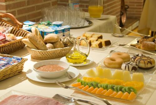 a table topped with plates of food and baskets of bread at Los Arcos in Segovia