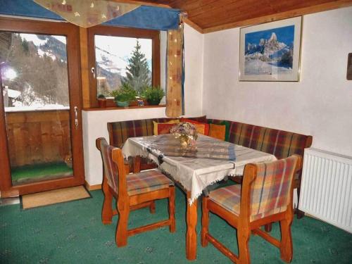ein Esszimmer mit einem Tisch, Stühlen und einem Fenster in der Unterkunft Rastnerhof in St. Lorenzen