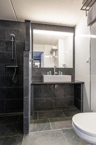 a bathroom with a sink and a mirror at Bastion Hotel Amsterdam Noord in Amsterdam