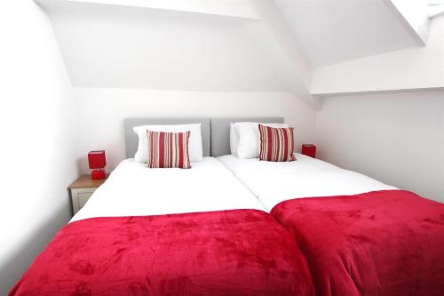 ein Schlafzimmer mit einer großen roten Decke auf einem Bett in der Unterkunft Coast Accommodation Station Road Apartments in Blackpool