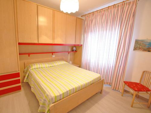 a small bedroom with a bed and a chair at Residence Antonella in Capoliveri