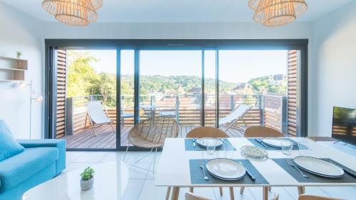 d'un salon avec une table et un balcon. dans l'établissement SWEET HOME Balcon Terrasse parking privé et linge compris, à Sarlat-la-Canéda