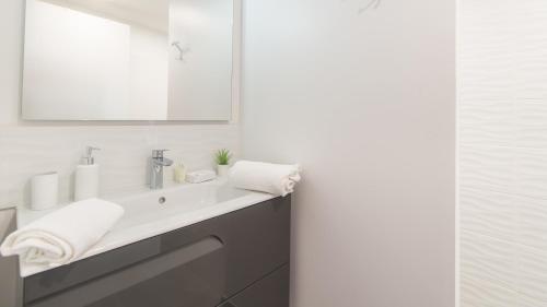 une salle de bain avec un lavabo et un miroir dans l'établissement SWEET HOME Balcon Terrasse parking privé et linge compris, à Sarlat-la-Canéda