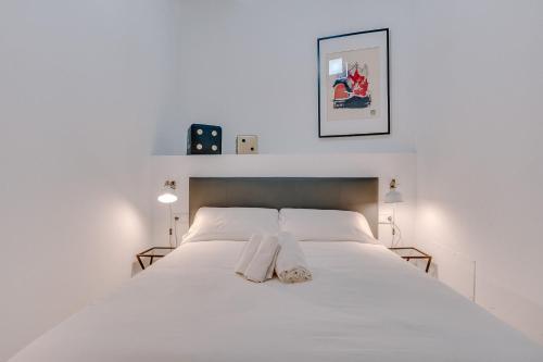 a white bedroom with a large white bed with two pillows at Vintage Palma Palace Apartments TI by PriorityVillas in Palma de Mallorca