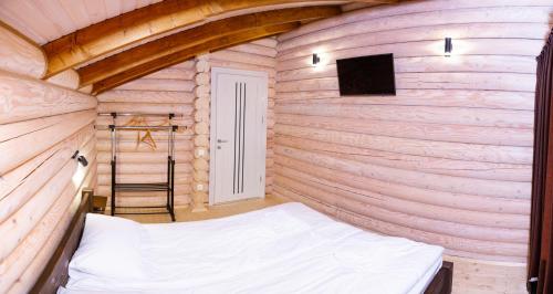 a small bedroom with a bed in a wooden wall at Шале Вілія in Vorokhta