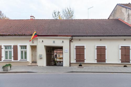 a white building with a flag in front of it at Apartments Satva in Vilnius