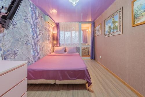 a bedroom with a purple bed in a room at Двухкомнатные апартаменты рядом с вокзалом in Sochi