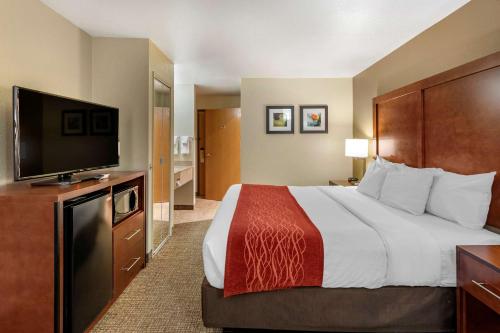 a hotel room with a bed and a flat screen tv at Comfort Inn Fontana in Fontana