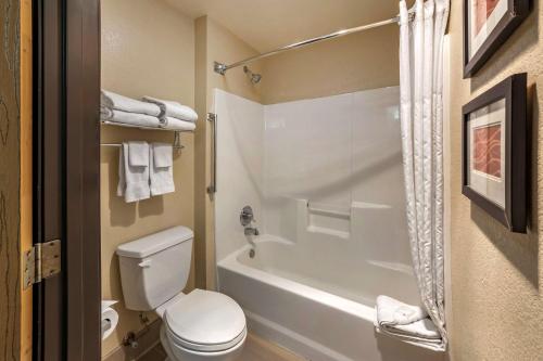 a bathroom with a white toilet and a bath tub at Comfort Inn Fontana in Fontana