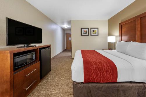 a hotel room with a bed and a flat screen tv at Comfort Inn Fontana in Fontana