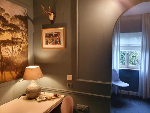 Zimmer mit einem Schreibtisch mit einer Lampe und einem Fenster in der Unterkunft Boutique Hotel Villa de Proosdij in Klimmen