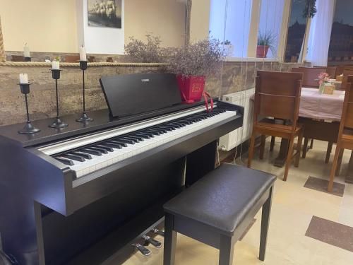a black piano sitting in a room with a chair at Karavella in Mykolaiv