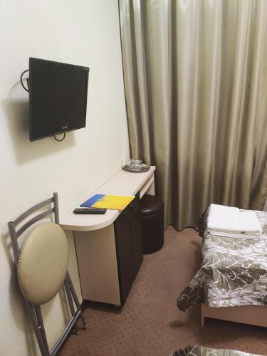 a room with a desk with a computer and a bed at Hotel Voyage in Kharkiv