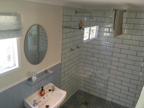 a bathroom with a sink and a mirror at Cheverells Farm, Kiku & Braeburn Cottage in Grabouw