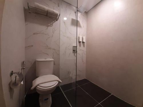 a bathroom with a toilet and a glass shower at Arte Hotel Yogyakarta in Yogyakarta