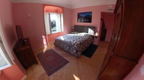 a bedroom with pink walls and a bed and a window at La Casa nel Parco Lecco in Lecco