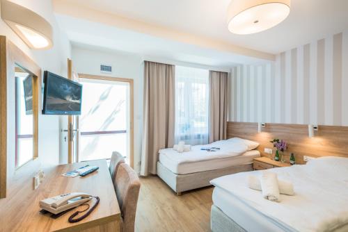 um quarto de hotel com duas camas e uma mesa em Dozamel em Colberga