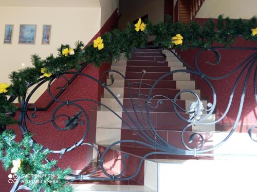 a stairway with flowers and a metal railing at Hotel Delfin in Mukacheve