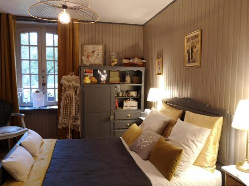 1 dormitorio con 1 cama con almohadas amarillas y blancas en Manoir de l'Alleu, en La Chapelle-Chaussée