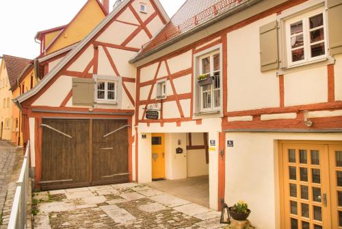 a house with a garage in a street at RefuKium Altstadtscheune in Weißenburg in Bayern