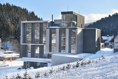 a building in the middle of a snow covered field at Grand Hotel Hradec in Pec pod Sněžkou