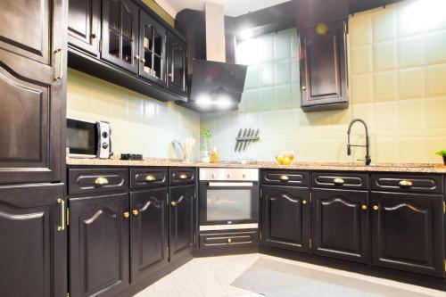 a kitchen with black cabinets and a sink at Regouro - an Hidden Gem in Douro Valley in Boassas