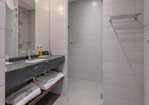 a bathroom with a sink and a shower at Solo Sokos Hotel Paviljonki in Jyväskylä
