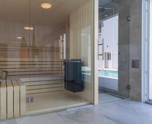 a bathroom with a glass wall next to a swimming pool at Villa Enigma in Dubrovnik
