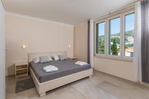 a bedroom with a bed and a large window at Villa Enigma in Dubrovnik