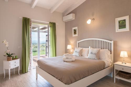 una camera con un grande letto e un balcone di Podere n°8 Agriturismo in Maremma ad Alberese