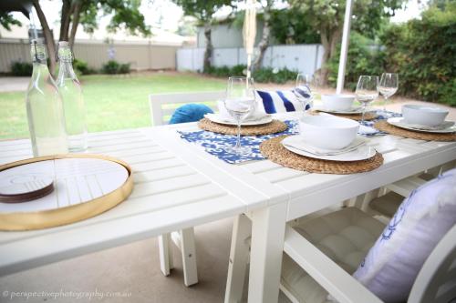 a white table with glasses and plates on it at The Sampson - Orange in Orange