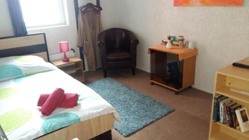 a bedroom with a bed and a chair and a desk at Pension am Piko-Platz in Sonneberg