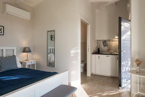 a bedroom with a blue bed and a bathroom at Podere n°8 Agriturismo in Maremma in Alberese