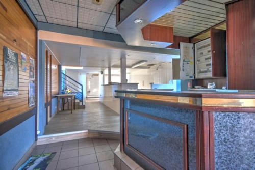 a kitchen with a bar with a hallway in the background at Ty Keramor in Hôpital-Camfrout