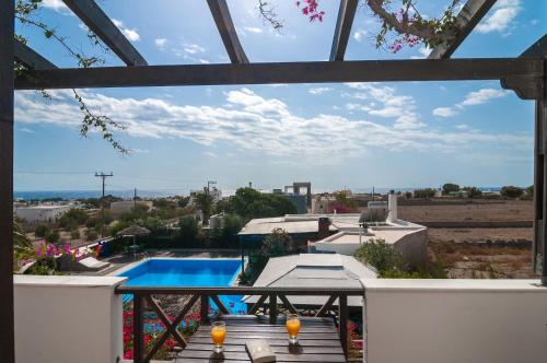 uma vista para uma piscina a partir da varanda de uma casa em Holiday Beach Resort Santorini em Perivolos