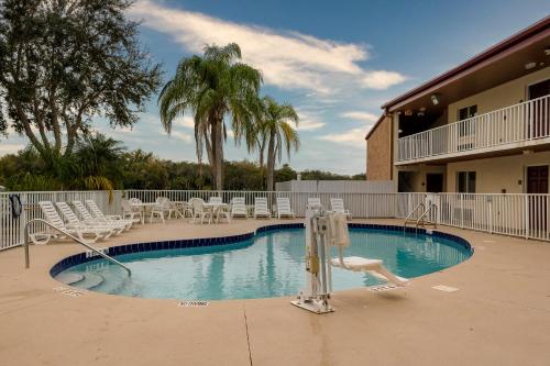 a swimming pool with chairs and a slide in a resort at Red Roof Inn Ellenton - Bradenton NE in Ellenton