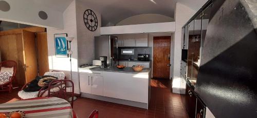 une cuisine avec un chien assis dans une chaise dans une pièce dans l'établissement PORT CIPRIANO Sur les toits , vue panoramique sur la mer, à Saint-Cyprien