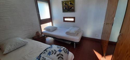 une petite chambre avec deux lits et une fenêtre dans l'établissement PORT CIPRIANO Sur les toits , vue panoramique sur la mer, à Saint-Cyprien