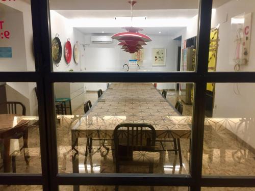 a dining room table with chairs and a large window at Art&Flats Hostel in Valencia