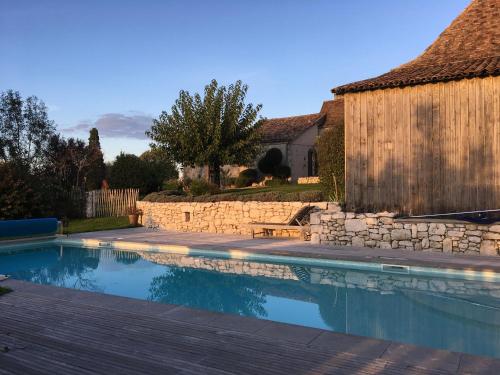 - une piscine dans une cour dotée d'un mur en pierre dans l'établissement La Ferme Buissonnière, à Bardou