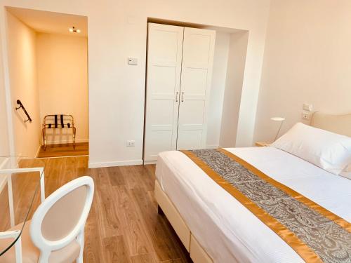 a bedroom with a bed and a desk and a chair at Grand Hotel San Lorenzo in Mantova