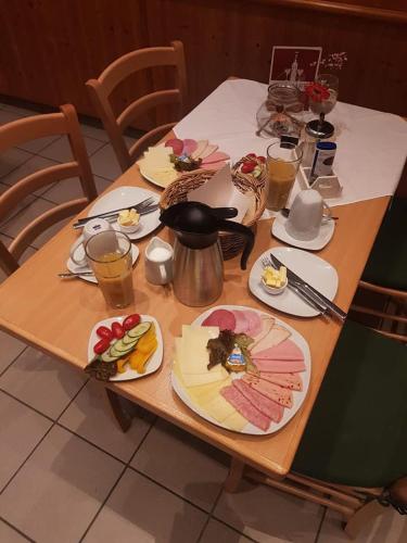une table en bois avec des assiettes de nourriture dessus dans l'établissement Hotel & Gasthof zur Post, à Neumarkt-Sankt Veit