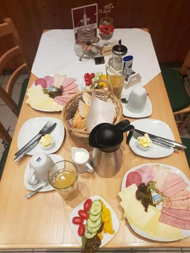 une table en bois avec des assiettes de nourriture dessus dans l'établissement Hotel & Gasthof zur Post, à Neumarkt-Sankt Veit