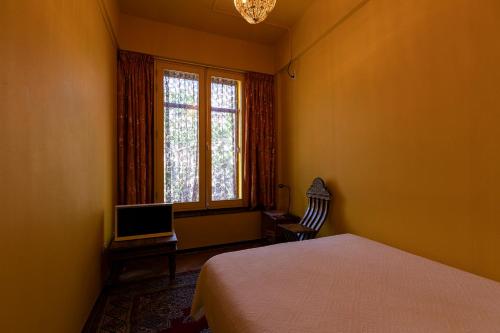 a bedroom with a bed and a desk with a laptop at Hotel Bazar in Rotterdam