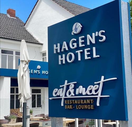 ein Schild vor einem Hotel mit einem weißen Regenschirm in der Unterkunft Hagen`s Hotel "eat & meet" Restaurant Bar Lounge in Haren