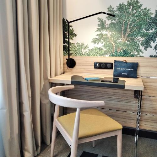 a desk with a chair in front of a window at Novotel Suites Montpellier Antigone in Montpellier