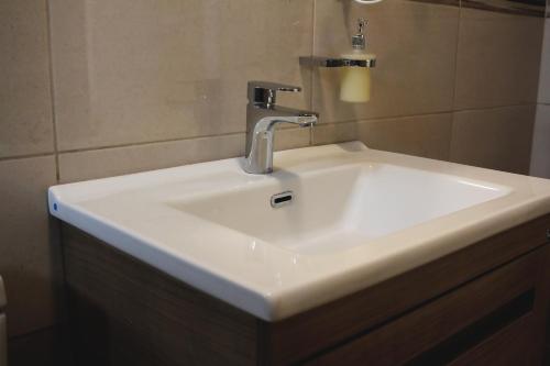 lavabo blanco con grifo en el baño en Ecco Superior en Novi Pazar