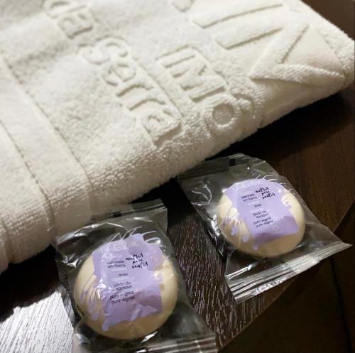 two packets of soap sitting next to a towel at Prime Hotel Águas da Serra in Rio Quente