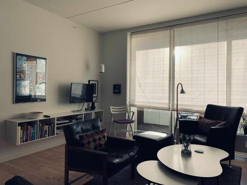 a living room with chairs and a table and a tv at ApartmentInCopenhagen Apartment 93 in Copenhagen