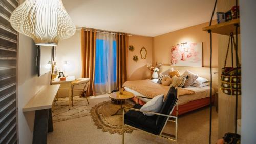 a bedroom with a bed and a desk and a chair at Kyriad Prestige Vannes Centre-Palais des Arts in Vannes